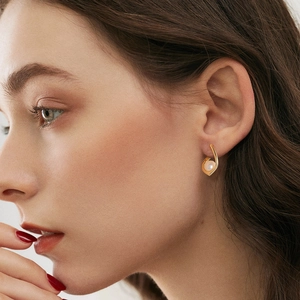 Élégante boucle d'oreille en argent 925 géométrique avec perle ronde portée par un modèle