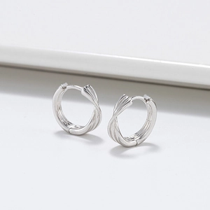 Gros plan de créoles en argent sterling S925 avec design croisé Mobius torsadé