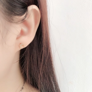 Gros plan de boucles d'oreilles croissants dorés serties de pierres sur modèle