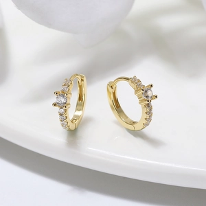 Détail de boucles d'oreilles créoles en argent S925 doré serties de zircones cubiques