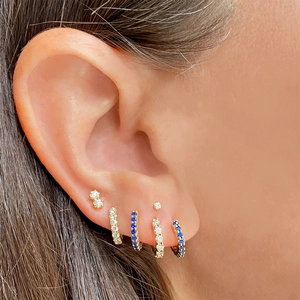 Detail of 925 silver earrings set with blue and clear stones on gold plating