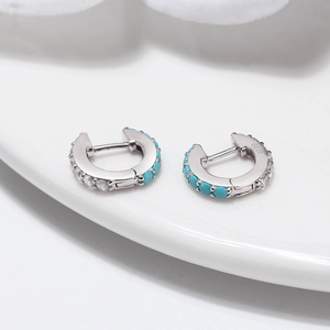 Macro detail showing S925 hallmark on silver huggie earrings with turquoise and zircons