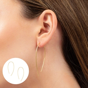 Detail shot of elegant gold irregular curved U-shaped dangle earrings on model