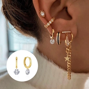 Detail of gold-plated S925 silver huggie earrings with round zircon drop on ear