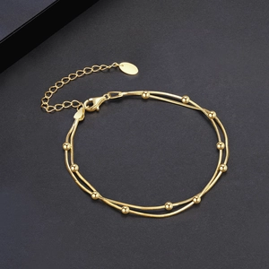 Double-layered 925 sterling silver beaded bracelet in gold finish on black background