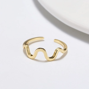 Détail macro d'une bague vague dorée montrant le poinçon S925 et l'anneau ajustable
