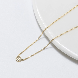 Détail du collier pendentif rond doré avec micro-pavage de zircons blancs
