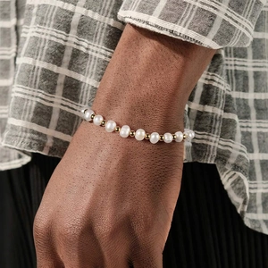 Elegant men's freshwater pearl bracelet with gold beads worn with a checkered shirt