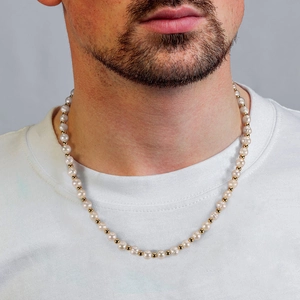 Dettaglio di perle d'acqua dolce e sfere placcate oro 14K su una collana da uomo elegante
