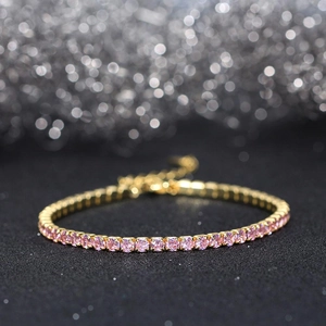 Close-up of golden tennis bracelet with pink cubic zirconia stones and lobster clasp