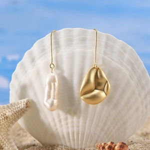 Detail of S925 silver hook earrings with asymmetric baroque pearl and gold shell design