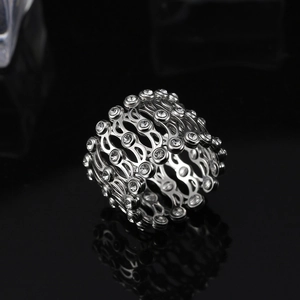 Détail macro d'une bague rétractable en argent S925 avec zircons et structure ondulée