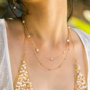 Close-up of double-layer 925 silver necklace with pearls and gold beads on a neck
