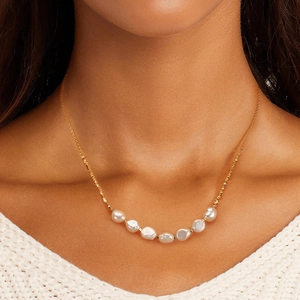 Elegant gold S925 silver necklace with seven baroque pearls on a model wearing knitwear
