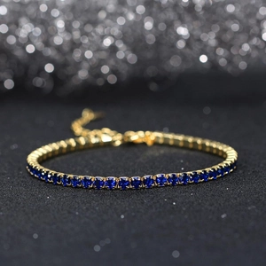 Detail of 3mm cubic zirconia tennis bracelet with gold setting and navy blue stones