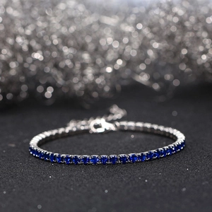 Macro detail of silver tennis bracelet with dark blue stones and adjustable lobster clasp