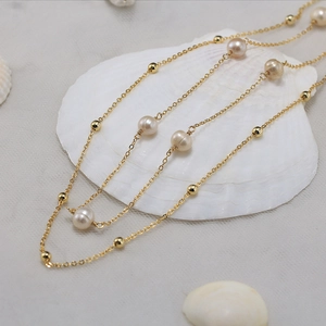 Elegant 925 sterling silver pearl necklace layered with golden beads on white shell