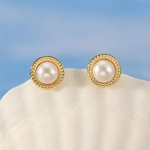Elegant 925 silver pearl stud earrings with gold wheat texture on a white shell