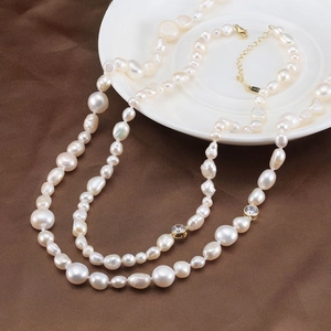 Collier de perles baroques avec des zircons dorés sur une assiette en céramique