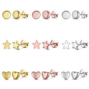 Détail macro de boucles d'oreilles en argent S925 en formes de cœur, étoile et rond