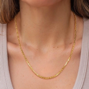Close-up of golden S925 sterling silver Byzantine chain necklace worn by a model