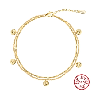 Nahaufnahme des doppelten S925 Sterling Silber Fußkettchens mit Vergoldung und Charms