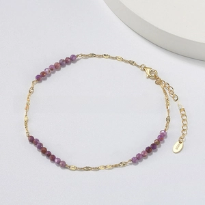 Close-up of S925 sterling silver butterfly anklet with purple faceted beads and gold finish