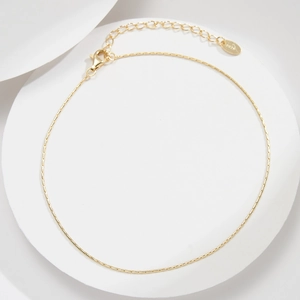 Dettaglio di una catena a bambù minimalista in argento S925 dorato con chiusura a moschettone