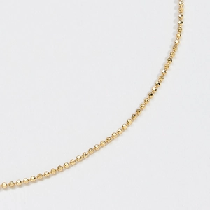 Macro shot of gold-plated S925 sterling silver ball chain featuring faceted round beads