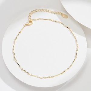 Detailed macro view of S925 sterling silver stamp on a gold twisted chain anklet