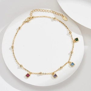 Detail of S925 sterling silver anklet with four colorful square zircons and golden beads