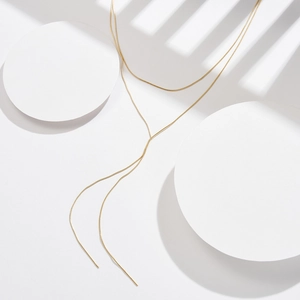 Detailed close-up of double-layered gold Y-shaped snake bone chain necklace design
