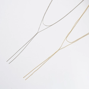 Detail of minimalist S925 sterling silver Y-shaped layered necklaces in gold and silver