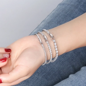 Gros plan de trois bracelets tennis en argent s925 sertis de zircons portés au poignet