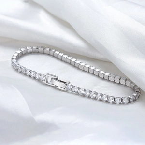Gros plan d'un bracelet de tennis en argent s925 avec zircons sur soie blanche