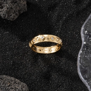 Macro shot of S925 sterling silver gold plated ring with zircons on volcanic sand