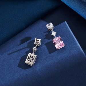 Gros plan sur des boucles d'oreilles en argent avec gemmes roses et motif cœur à l'arrière