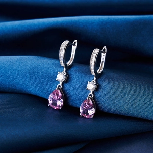 Macro detail of S925 sterling silver hoop earrings with pink pear-shaped drop stones