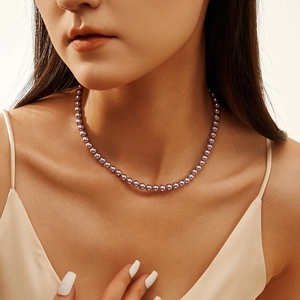 Elegant purple pearl necklace shown on model's neckline for a luxury vintage look