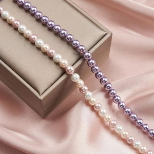 Detail of purple and mixed pastel pearl necklaces on champagne gold jewelry box