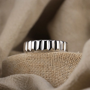 Macro shot of silver metal ring with mechanical gear texture on natural linen fabric