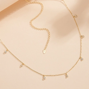 Détail du poinçon S925 sur une chaîne de ventre dorée avec pendentifs en zircon