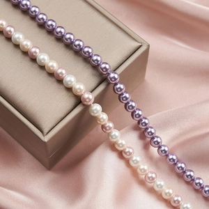 Detail shot of colorful pearl necklaces on silk fabric showing soft luster and fine texture