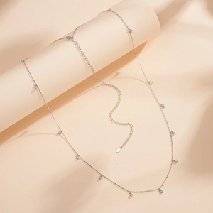 Détail d'une chaîne de taille en argent S925 avec pendentifs en zircon sur fond élégant
