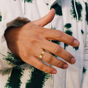 Close-up of golden S925 silver ring with triple parallel grooves on male model's finger