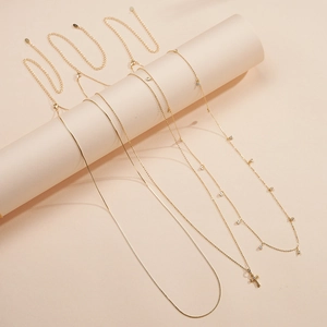 Detailed view of 4-piece set of gold cross and rhinestone pendant necklaces layered