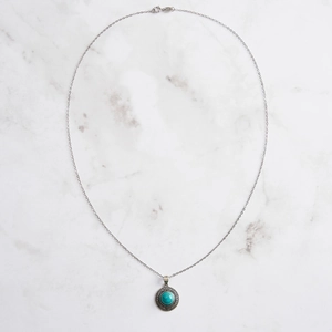 Collier vintage en argent sterling S925 avec pendentif rond turquoise sur fond marbre
