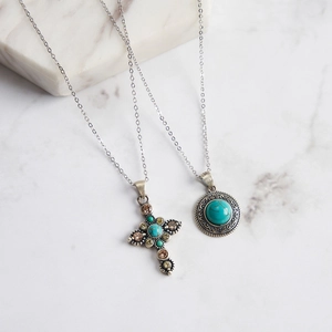 Gros plan de colliers en argent 925 avec pendentifs croix et médaille en turquoise rétro