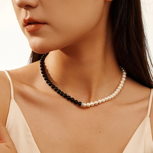 Collier élégant bicolore avec obsidienne noire et perles blanches porté par un mannequin