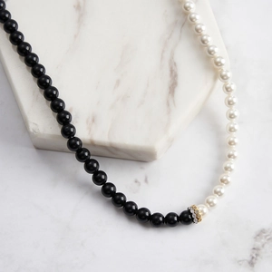 Vue macro d'un élégant collier en obsidienne noire et perles avec entretoises en cristal